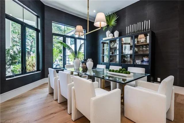 a dining room with furniture a chandelier and wooden floor