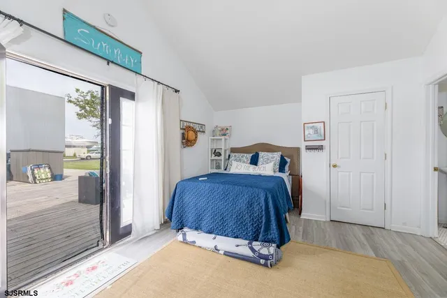 a bedroom with a bed and large windows