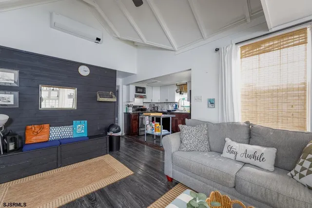 a living room with furniture and a flat screen tv next to a window