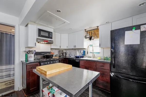 a kitchen with a refrigerator a stove a microwave a sink dishwasher and wooden cabinets