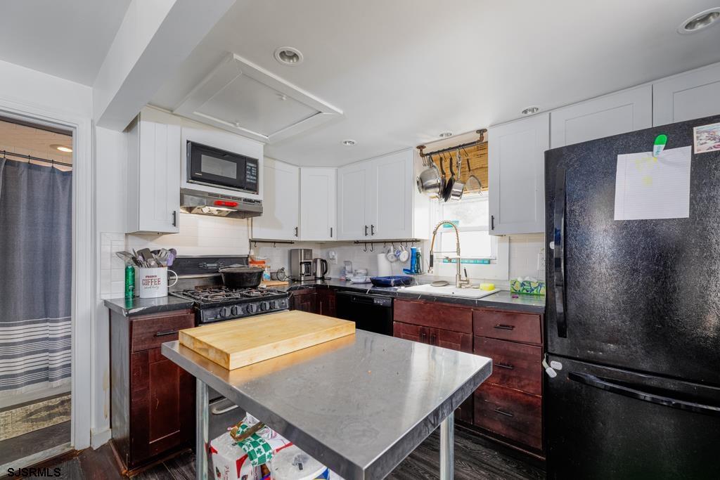 100 Decatur Avenue Somers Point, NJ 08244 - Photo 8 of 52 a kitchen with a refrigerator a stove a microwave a sink dishwasher and wooden cabinets