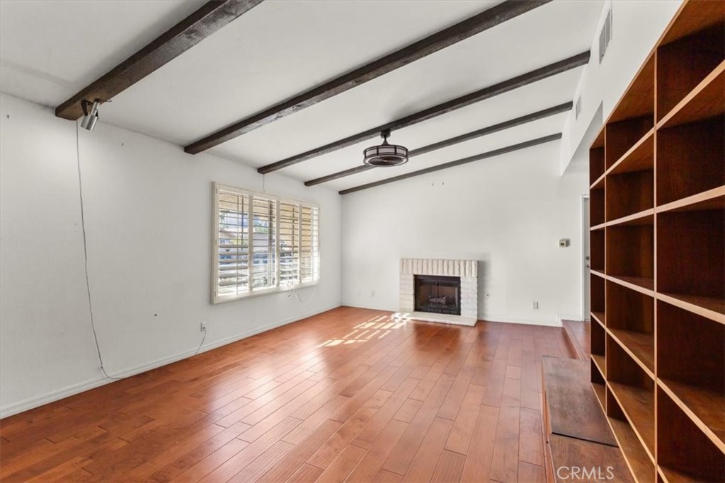 2250 Tamarisk Road Palm Springs, CA 92262 - Photo 16 of 36 a view of an empty room with wooden floor fireplace and a window