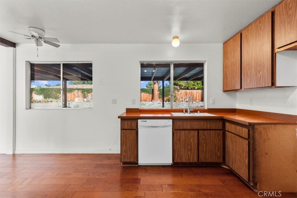 2250 Tamarisk Road Palm Springs, CA 92262 - Photo 20 of 36 a kitchen with stainless steel appliances granite countertop a sink and wooden cabinets