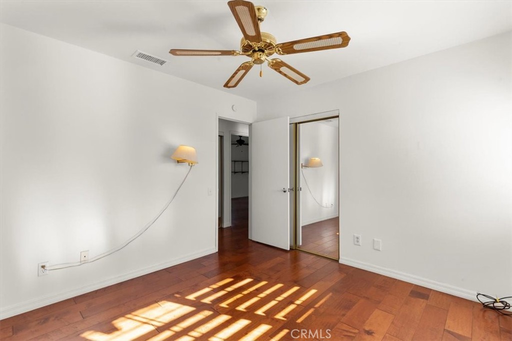 2250 Tamarisk Road Palm Springs, CA 92262 - Photo 27 of 36 a view of an empty room with wooden floor and a ceiling fan