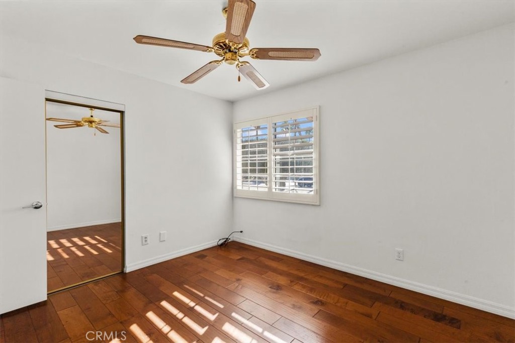 2250 Tamarisk Road Palm Springs, CA 92262 - Photo 28 of 36 an empty room with wooden floor fan and windows