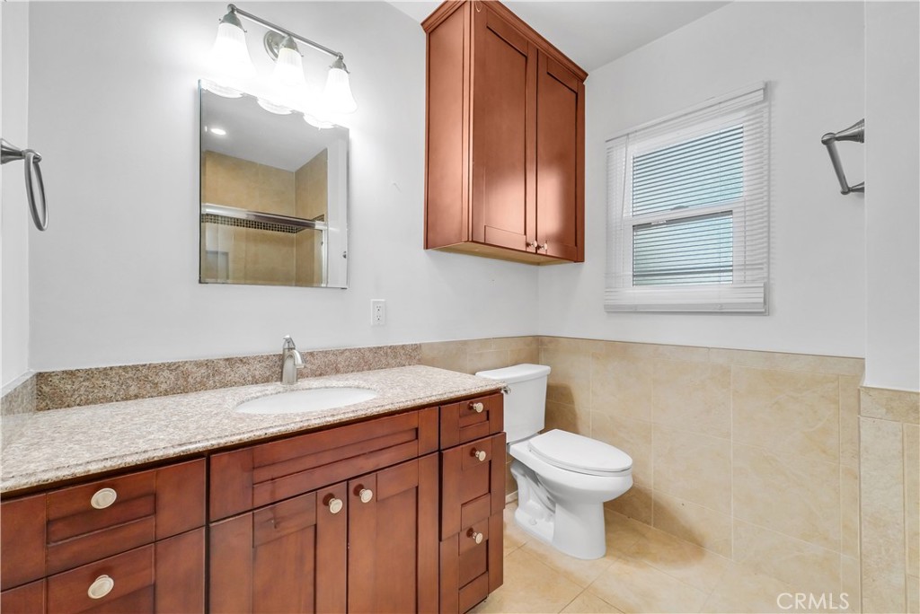 3921 Heidi Road Riverside, CA 92504 - Photo 11 of 20 a bathroom with a granite countertop toilet sink and mirror