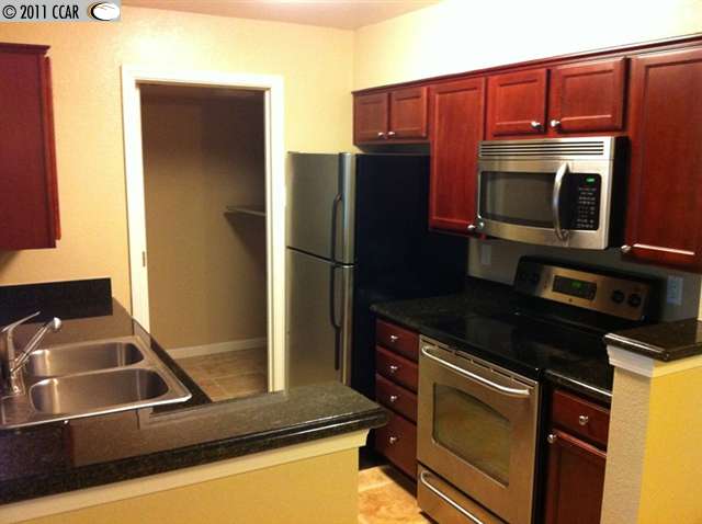 235 Reflections Drive, Unit 13 San Ramon, CA 94583 - Photo 1 of 1 a kitchen with a refrigerator stove and microwave
