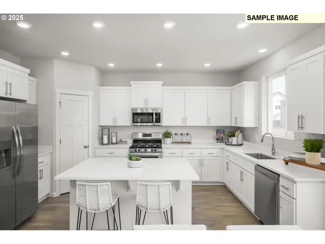 a kitchen with stainless steel appliances a sink a stove a refrigerator cabinets and a center island