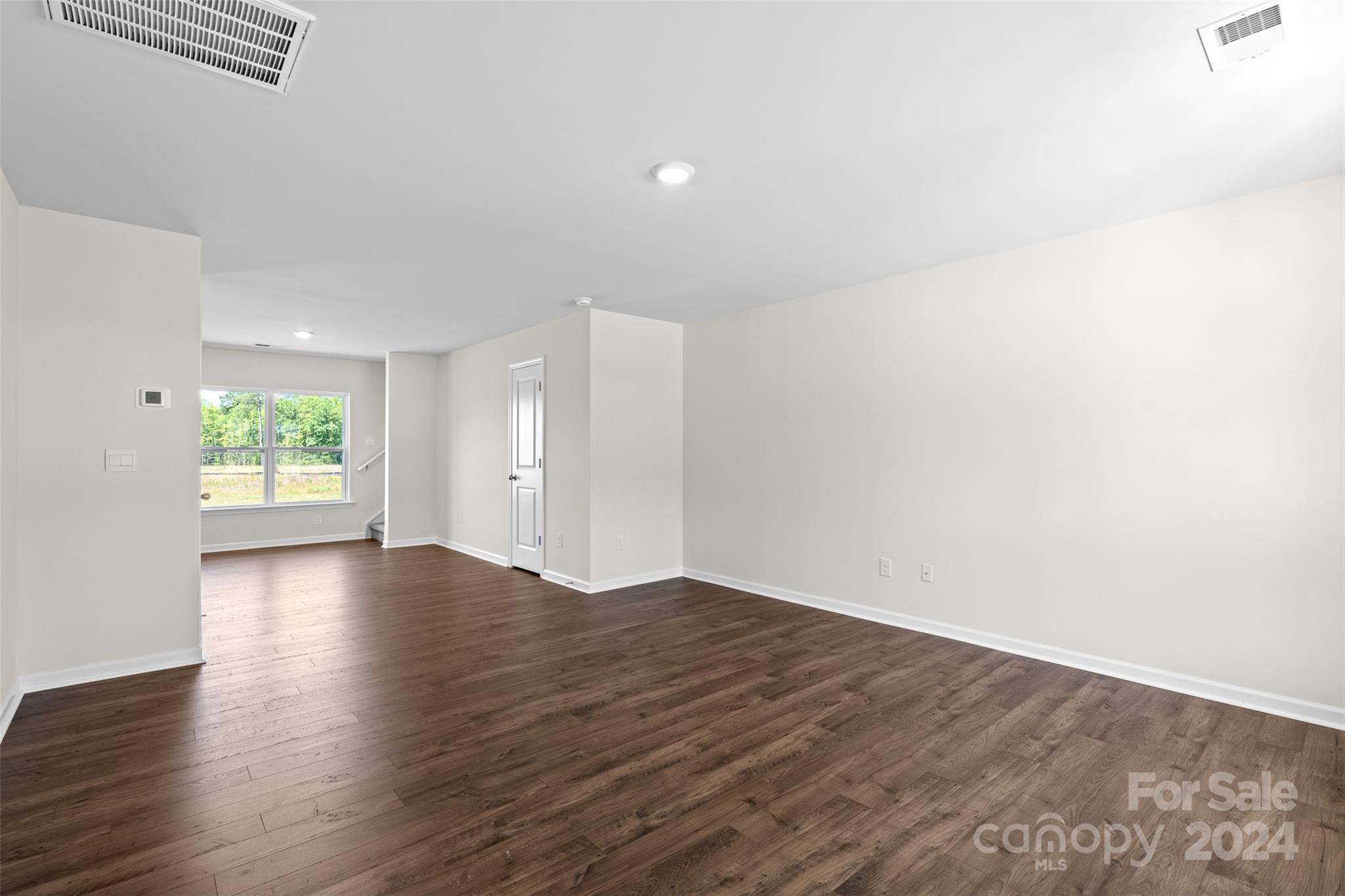 100 Callie River Clyde, NC 28721 - Photo 4 of 22 an empty room with wooden floor and windows