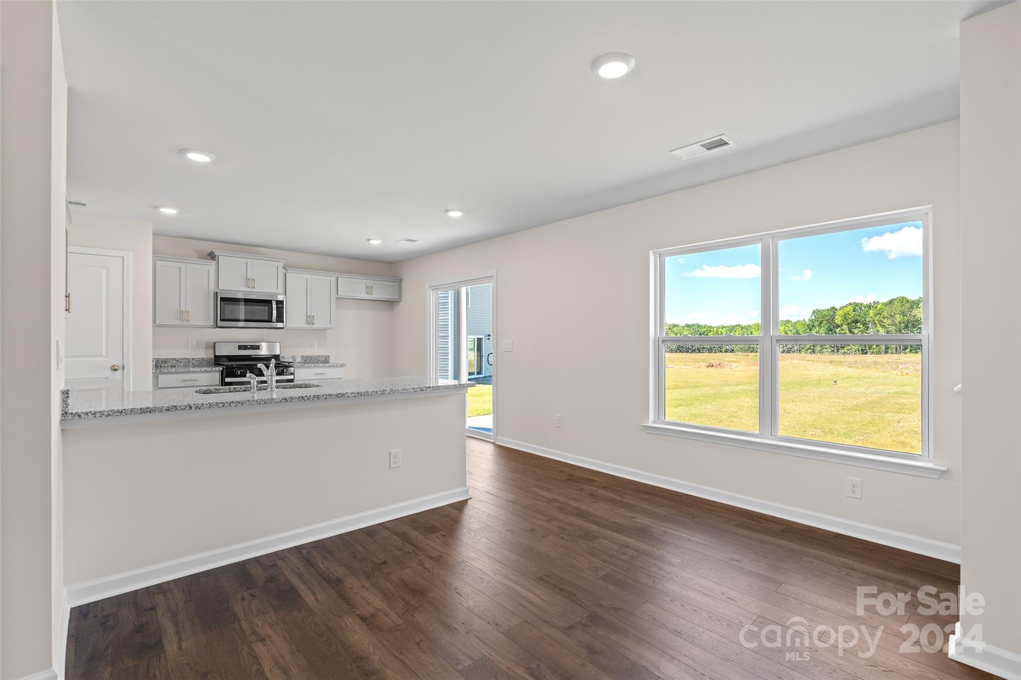 100 Callie River Clyde, NC 28721 - Photo 6 of 22 a kitchen with stainless steel appliances granite countertop a stove a sink a refrigerator white cabinets and a large window