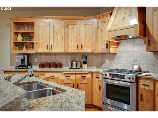 a kitchen with granite countertop a sink a stove and cabinets