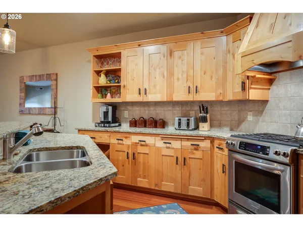 a kitchen with stainless steel appliances granite countertop a sink stove and cabinets