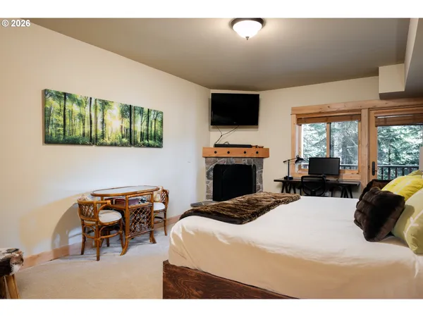 a bedroom with a bed a flat screen tv and a large window