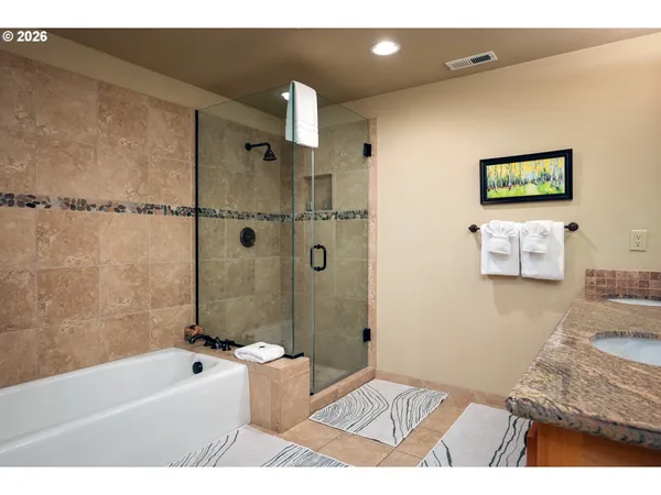 a bathroom with a granite countertop sink a toilet a bathtub and shower
