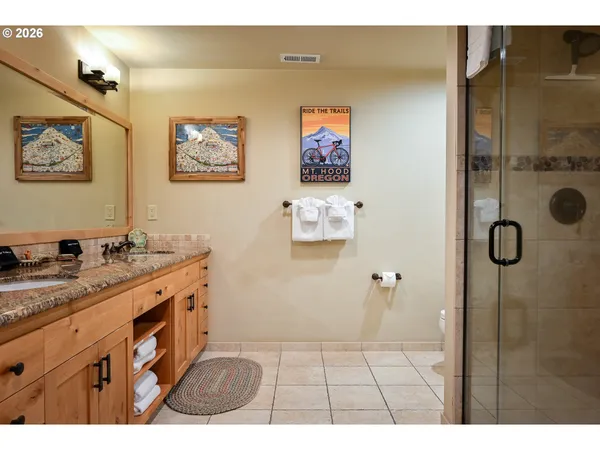 a bathroom with a granite countertop double vanity sink and a mirror