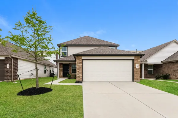 a front view of a house with a yard and garage