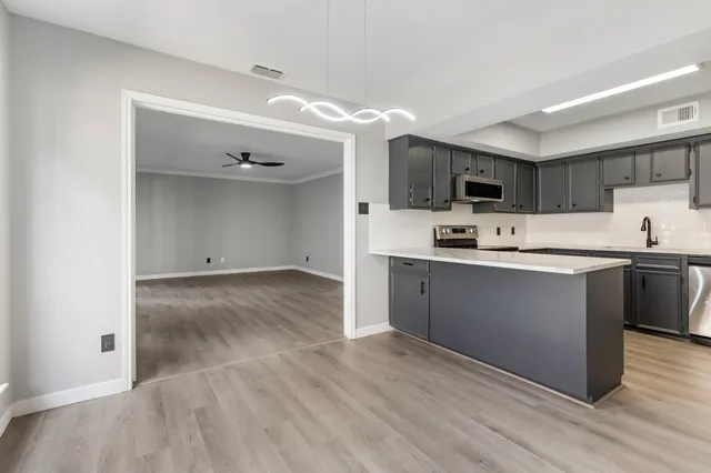 a kitchen with kitchen island a refrigerator sink and cabinets