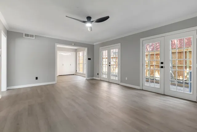 a view of an empty room with glass door and a window