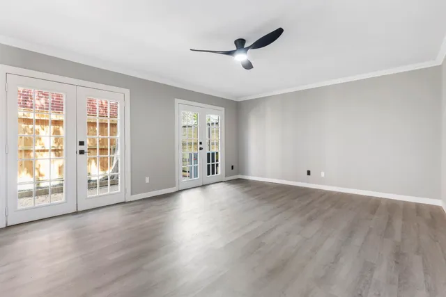 a view of an empty room with a window and wooden floor