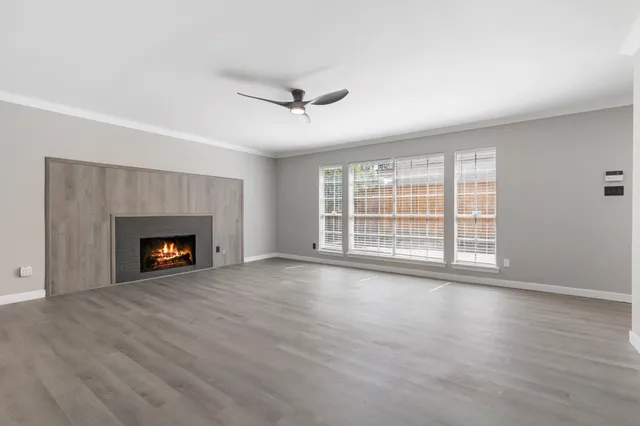 a view of an empty room with a fireplace and a window