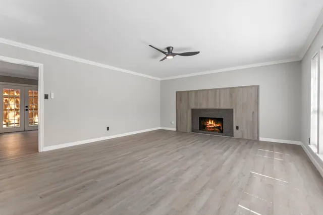 a view of empty room with wooden floor and fireplace