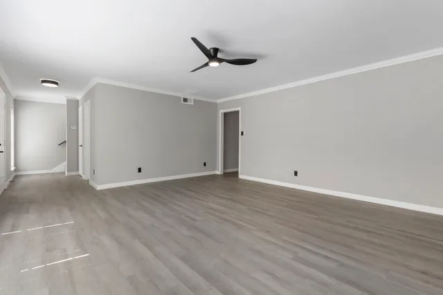a view of a livingroom with wooden floor and a ceiling fan