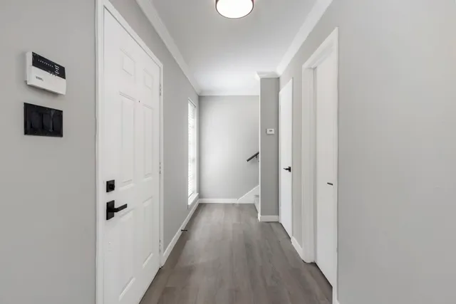 a view of a hallway with wooden floor and closet