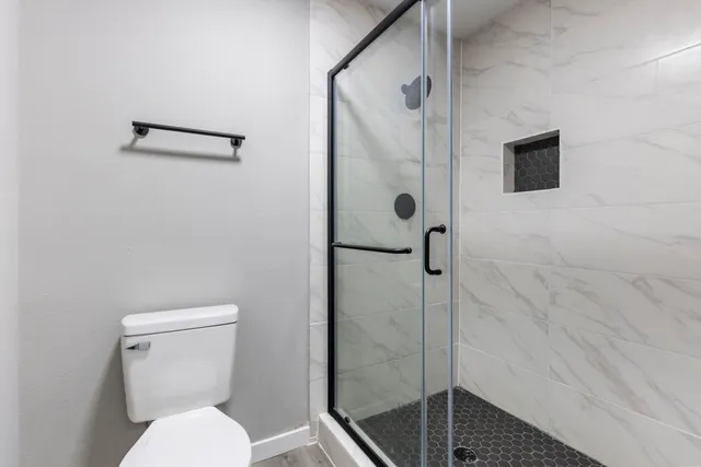 a bathroom with a toilet and a shower
