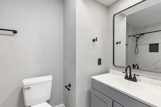 a bathroom with a sink toilet and mirror