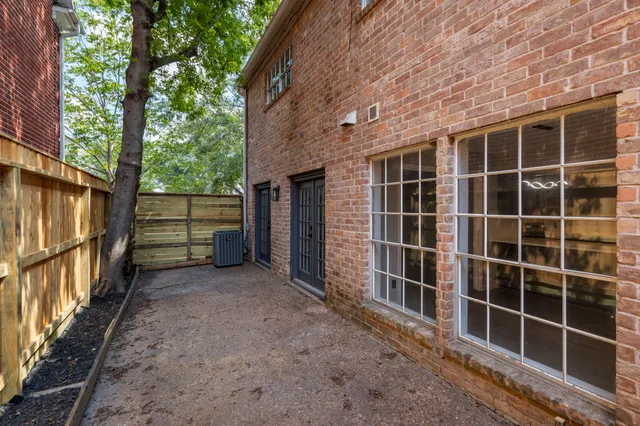 a view of a wooden house with a large window and wooden fence