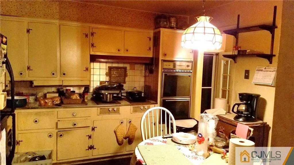 572 New Dover Road Colonia, NJ 07067 - Photo 2 of 10 a kitchen with stainless steel appliances a sink a refrigerator white cabinets and wooden floor