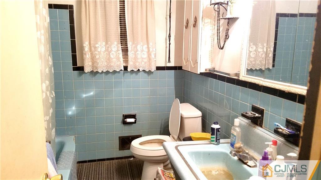 572 New Dover Road Colonia, NJ 07067 - Photo 5 of 10 a bathroom with a sink toilet and mirror