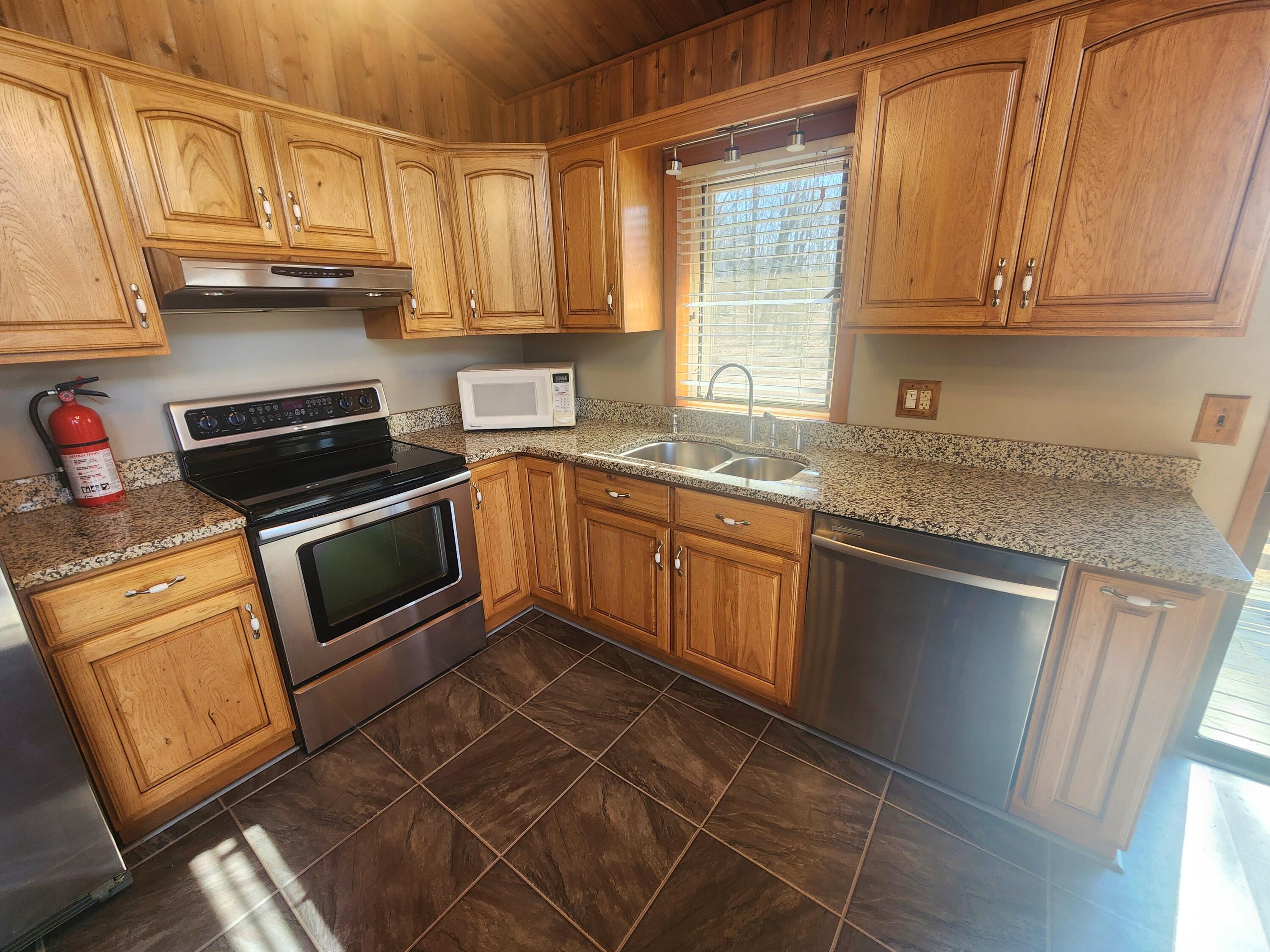 2263 Cramer Road Bushkill, PA 18324 - Photo 14 of 70 a kitchen with stainless steel appliances granite countertop a sink stove and microwave