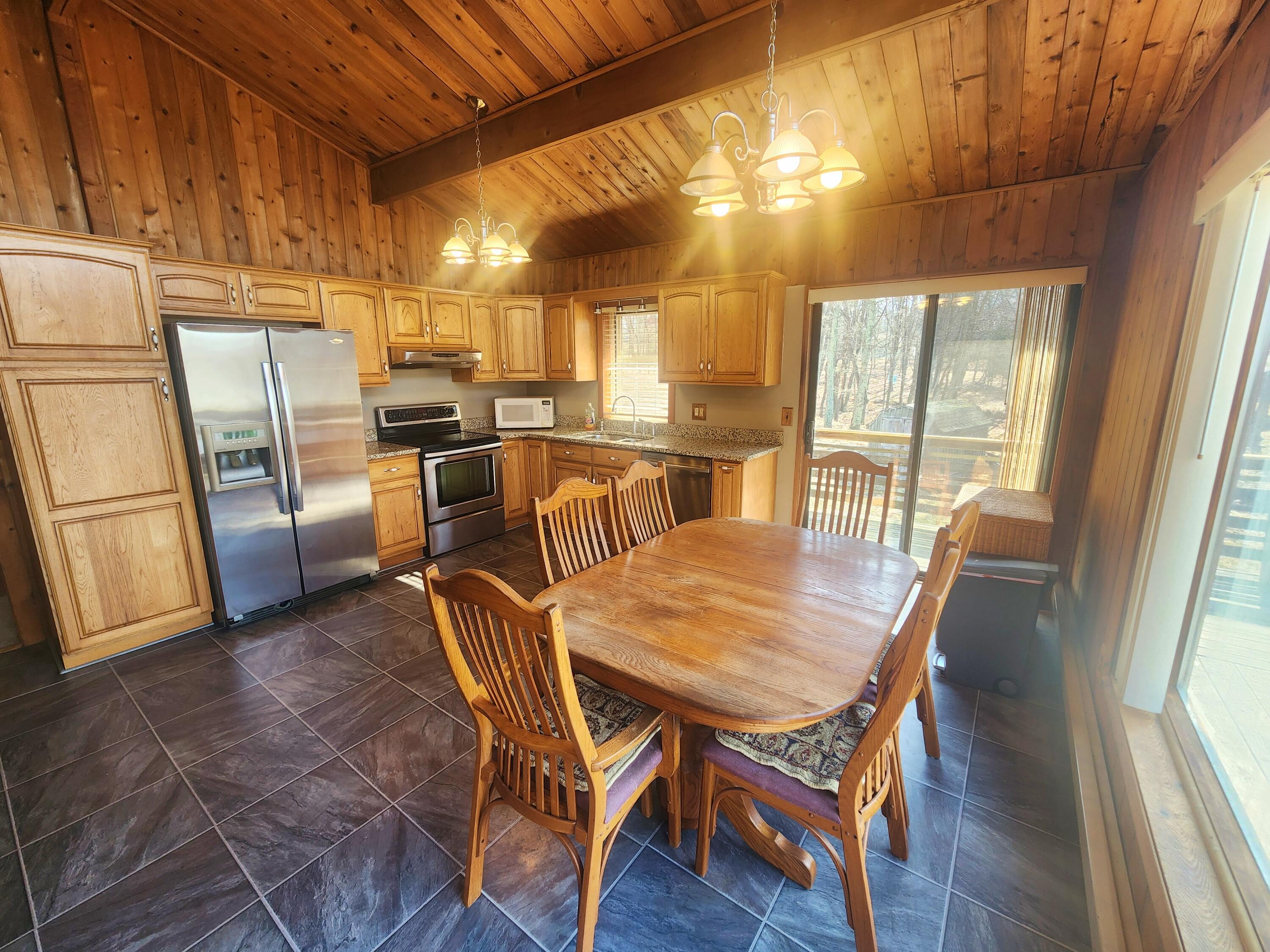 2263 Cramer Road Bushkill, PA 18324 - Photo 16 of 70 a view of a dining room with furniture large window and wooden floor
