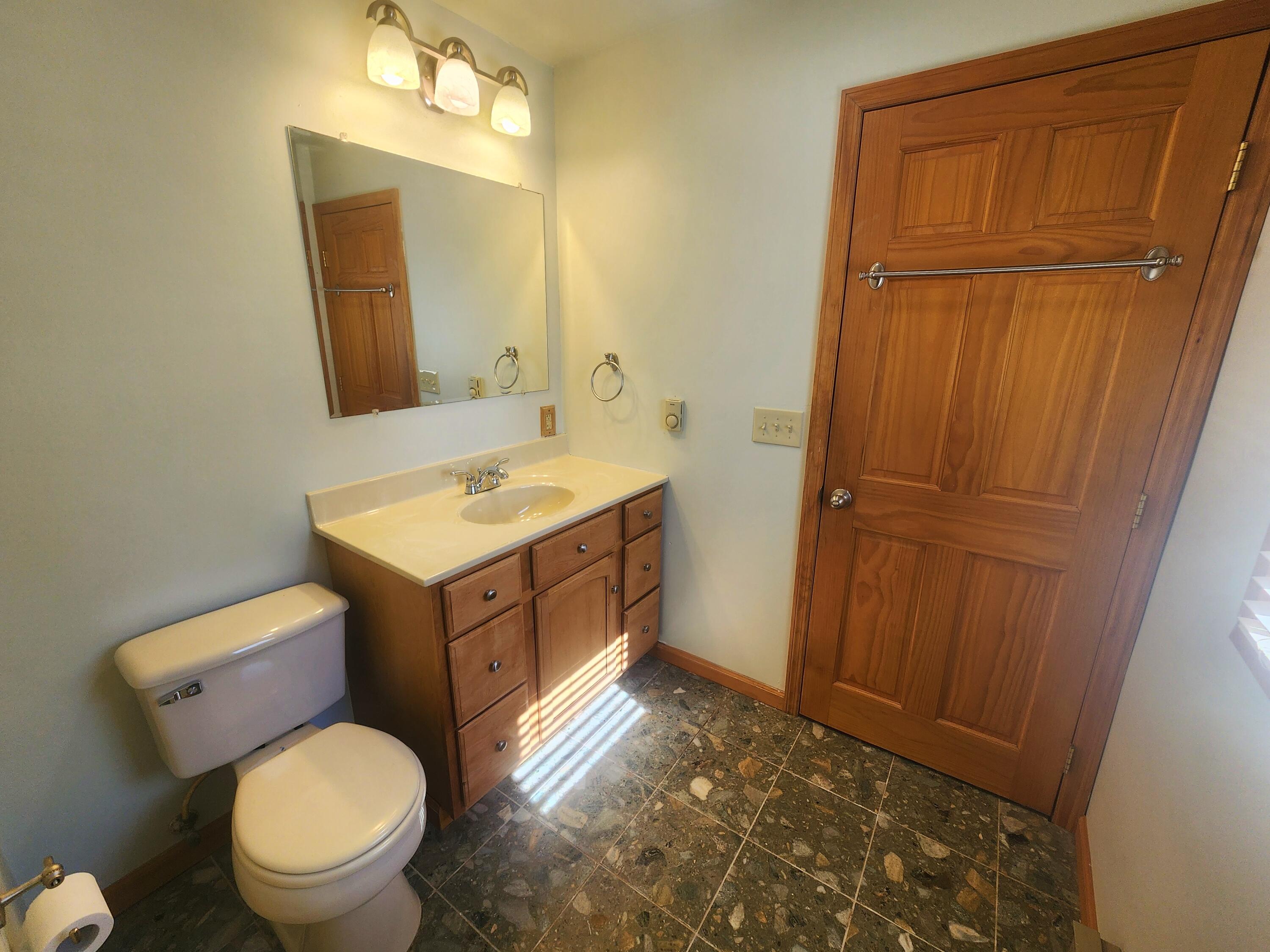 2263 Cramer Road Bushkill, PA 18324 - Photo 32 of 70 a bathroom with a toilet sink vanity and mirror