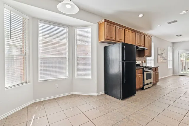 a kitchen with stainless steel appliances a refrigerator and a stove top oven