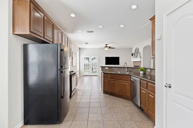 a kitchen with stainless steel appliances granite countertop a refrigerator and a sink