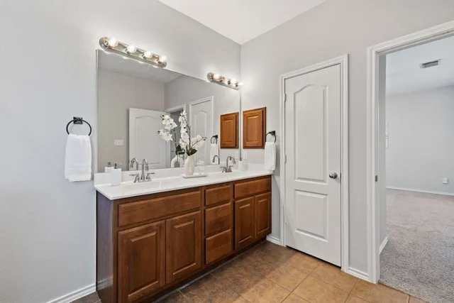 a bathroom with a double vanity sink and a mirror