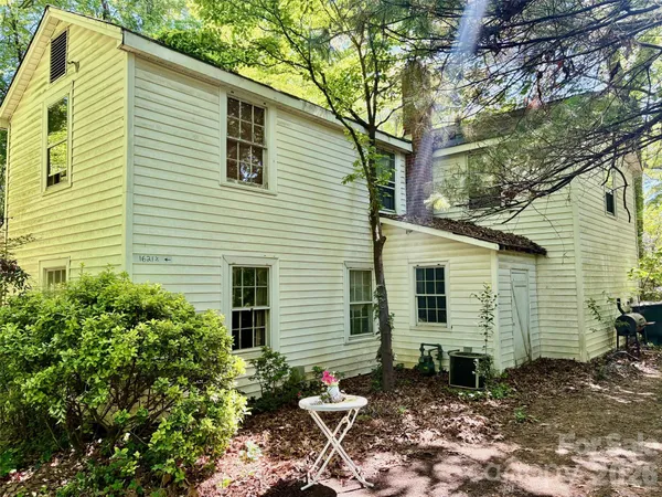a backyard of a house with table and chairs
