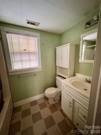 a bathroom with a granite countertop toilet a sink and a mirror