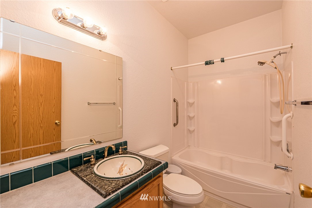 13 North Eldridge Road Sequim, WA 98382 - Photo 13 of 23 a bathroom with a granite countertop sink toilet mirror and shower