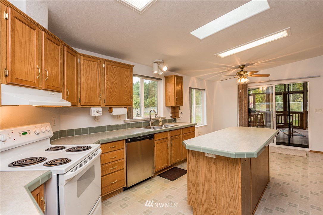 13 North Eldridge Road Sequim, WA 98382 - Photo 7 of 23 a kitchen with a sink stove and cabinets