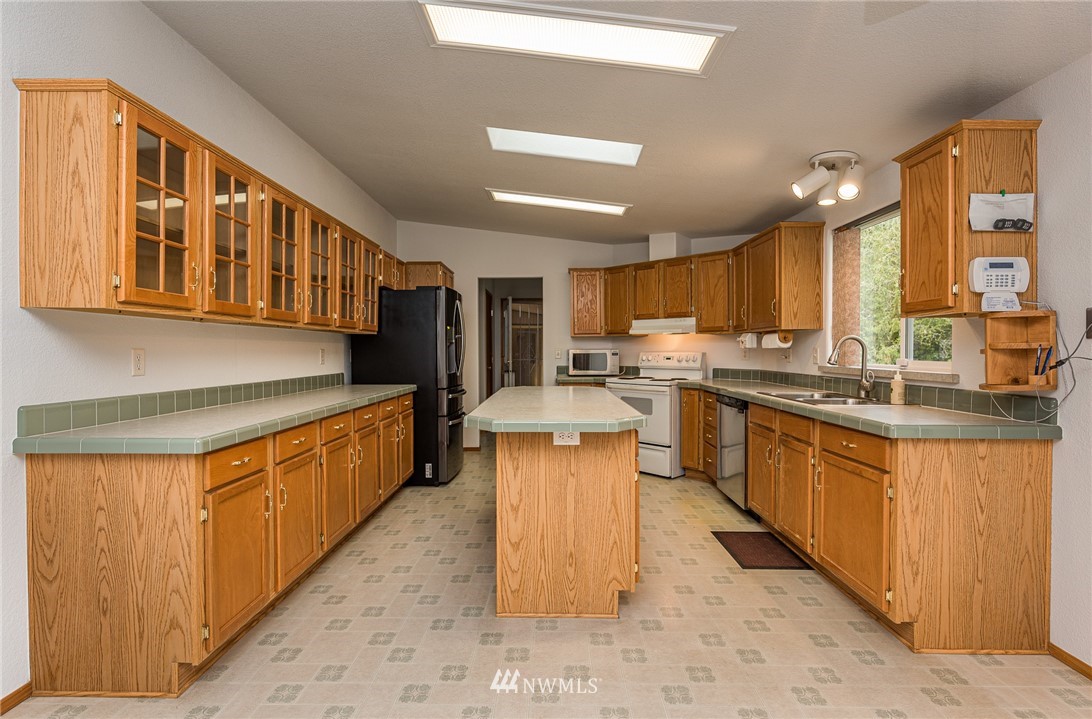 13 North Eldridge Road Sequim, WA 98382 - Photo 8 of 23 a kitchen with stainless steel appliances kitchen island granite countertop a stove refrigerator and cabinets