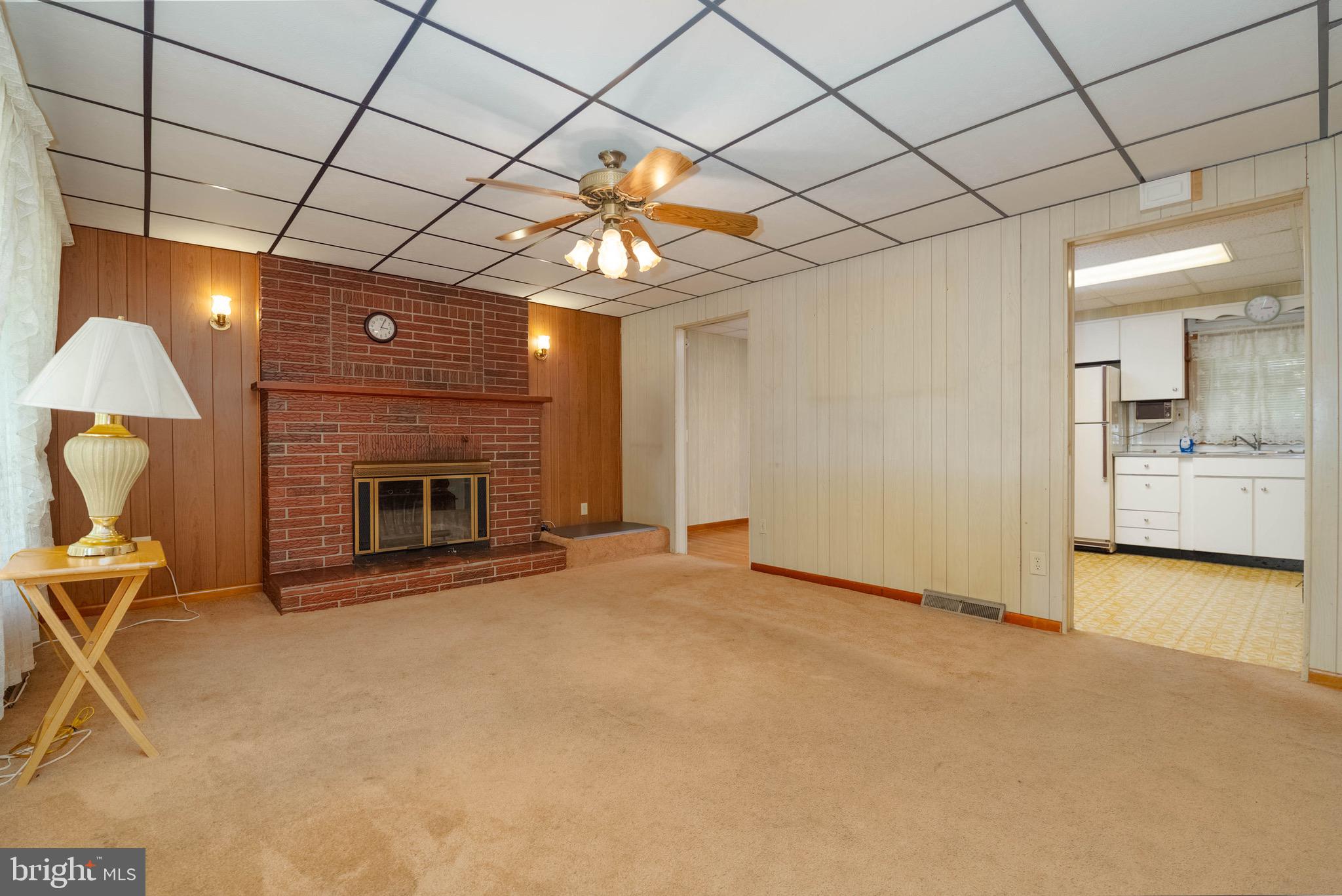 1709 Turkey Point Road Baltimore, MD 21221 - Photo 5 of 42 a view of an empty room with a fireplace and a chandelier fan