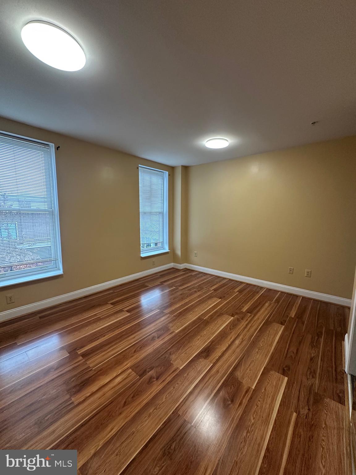 422 West Franklin Street, Unit 1B Baltimore, MD 21201 - Photo 13 of 17 an empty room with wooden floor and windows