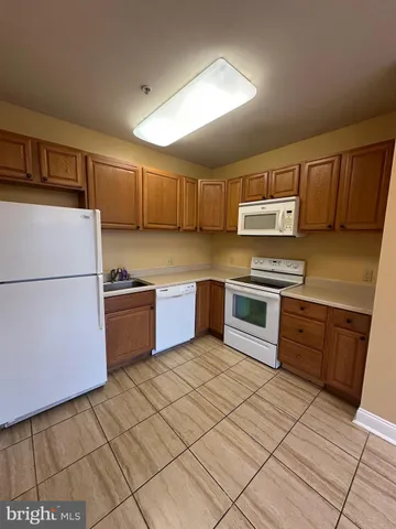 a kitchen with stainless steel appliances a stove a sink and a refrigerator