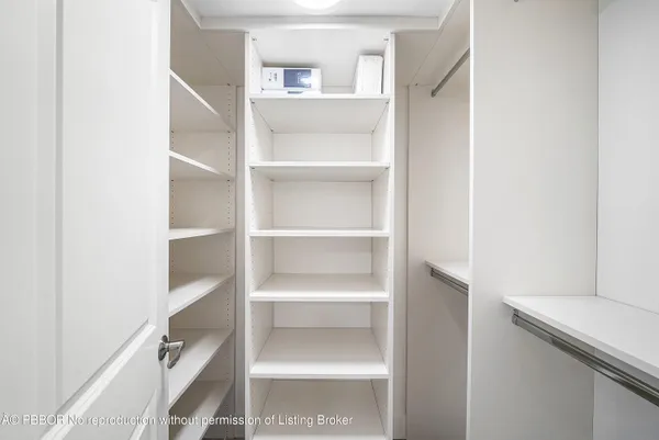 a view of walk in closet with empty racks