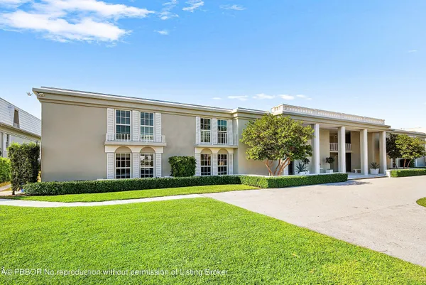 a view of a house with a big yard and large trees