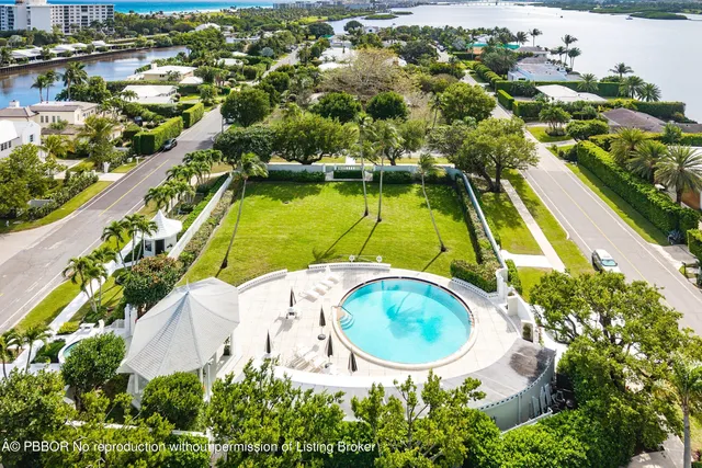 an aerial view of a swimming pool with a yard and lake view