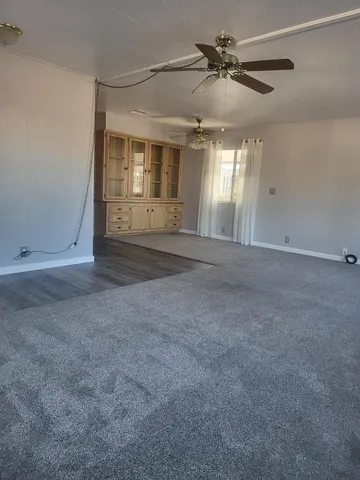 a view of a livingroom with a ceiling fan and window